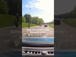 Stupid kid do wheelie in heavy traffic on a scooter/moped.