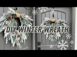 DIY cascading winter wreath with flocked evergreens and pinecones